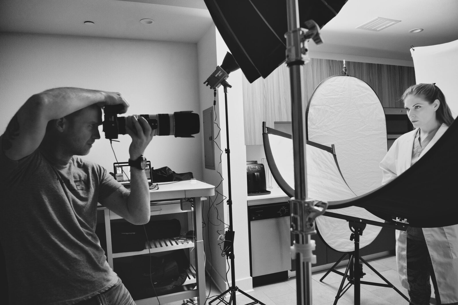 Black and white photo of the photographer shooting between softboxes