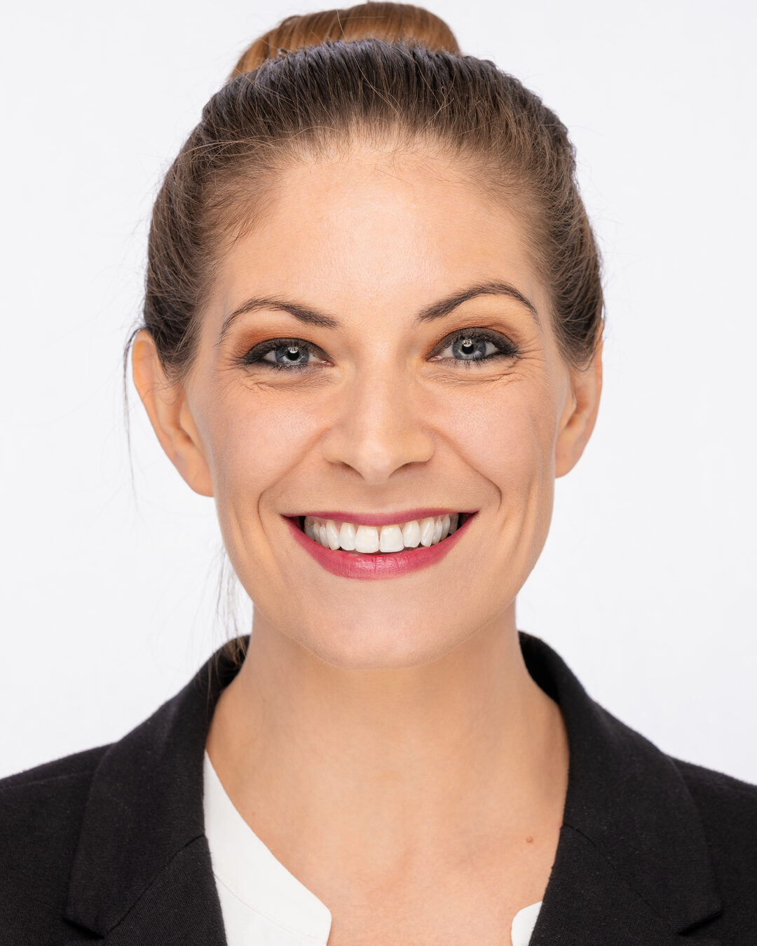 Cat with hair in a bun and a bright open smile, black blazer, commercial energy